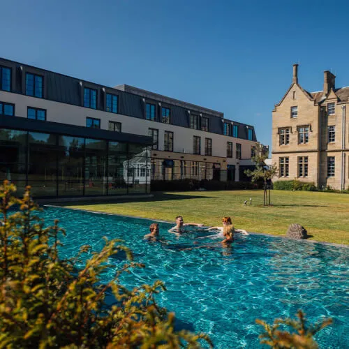 Relax and rejuvenate at the outdoor heated infinity pool at SCHLOSS Spa, your wellness retreat.