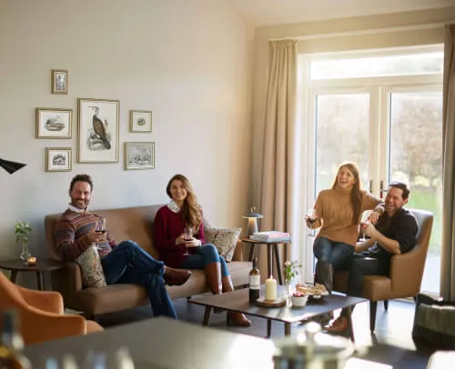 Friends enjoying drinks in a cozy living room at Roxburghe Hotel Golf & Spa.