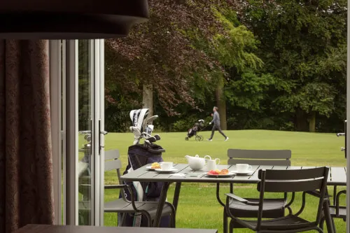 View from Roxburghe Hotel Golf & Spa Ltd. showing a golfer and a table with food.