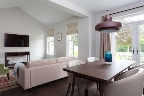 Modern hotel room interior with a dining space and living area.