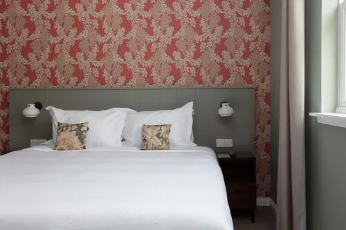 Cozy hotel room at Roxburghe Hotel featuring a double bed and floral wallpaper.