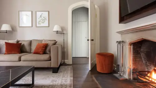 Elegant living space at Roxburghe Hotel, featuring a cozy sofa and a warm fireplace.