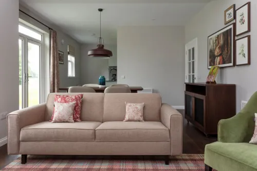 Cozy two-bedroom cottage with a golf view, featuring a sofa and an armchair.