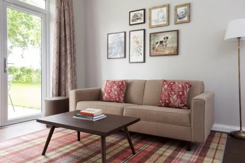 Cozy living room at Roxburghe Hotel with a sofa, table, and framed art.